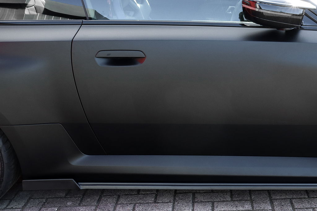 Seitenschweller mit Wing aus ABS für BMW M2 G87, schwarzes Tuning-Teil von Ingo Noak Tuning, sichtbar auf dem Auto.