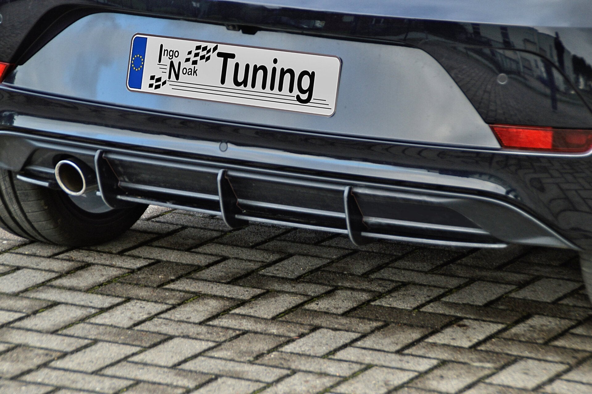 Racing Heckansatz für VW UP GTI, schwarzes Tuning-Bodykit von Ingo Noak Tuning auf einem Auto montiert.