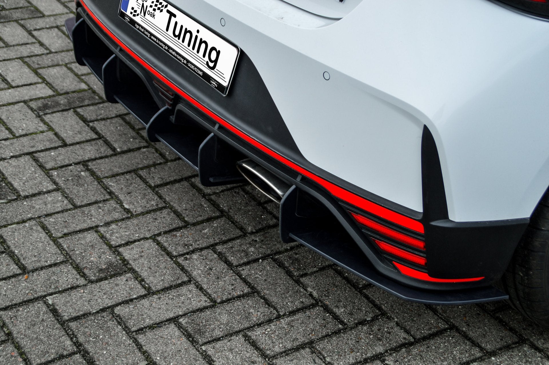 Rennheckansatz für Hyundai I20N Performance, schwarzes Tuning-Teil von Ingo Noak Tuning, sichtbar in der Abbildung