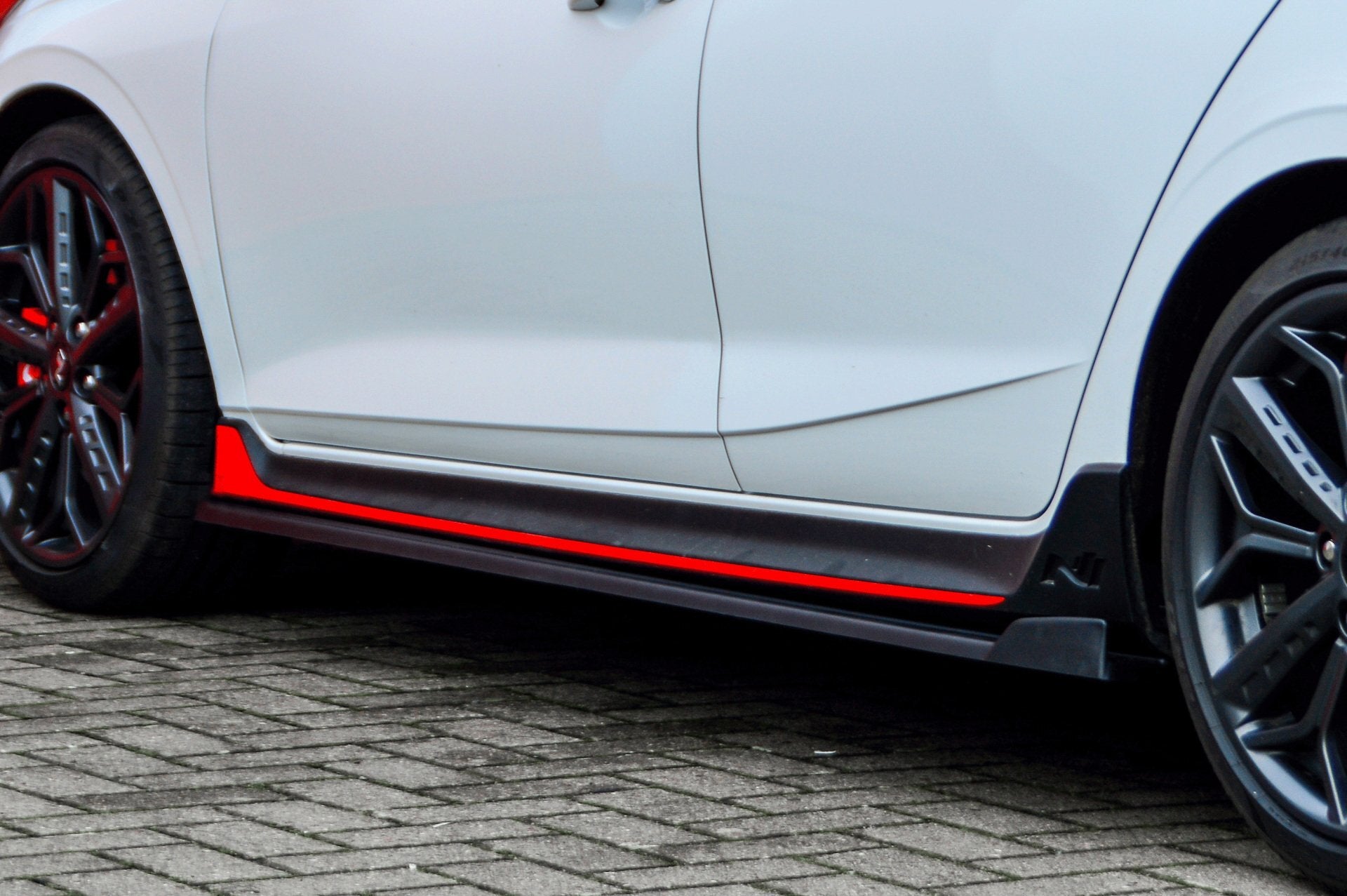 Seitenschweller mit Wing für Hyundai I20N Performance, schwarzes Tuning-Teil von Ingo Noak Tuning, sichtbare Fahrzeugteile