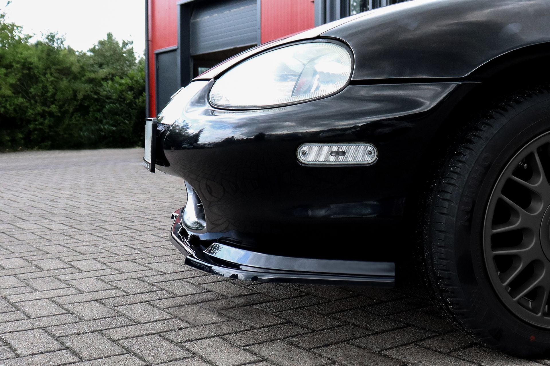 Schwarze ABS Cuplippe Frontspoilerlippe für Mazda MX5 NB von Ingo Noak Tuning, sichtbar auf dem Fahrzeug montiert.