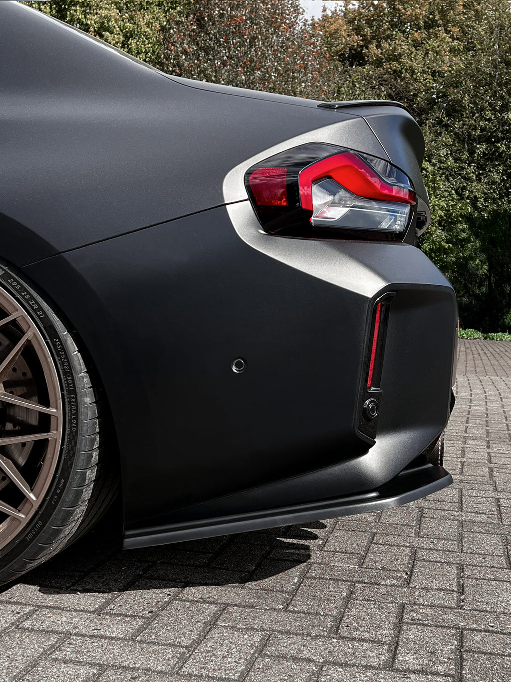 Seitenteile aus ABS für BMW M2 G87, Heckansatz, in schwarzem Finish, von Ingo Noak Tuning, sichtbar auf dem Bild.
